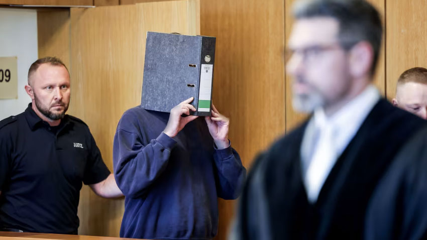 The nurse pictured hiding his face as he enters the courtroom on Wednesday. AP